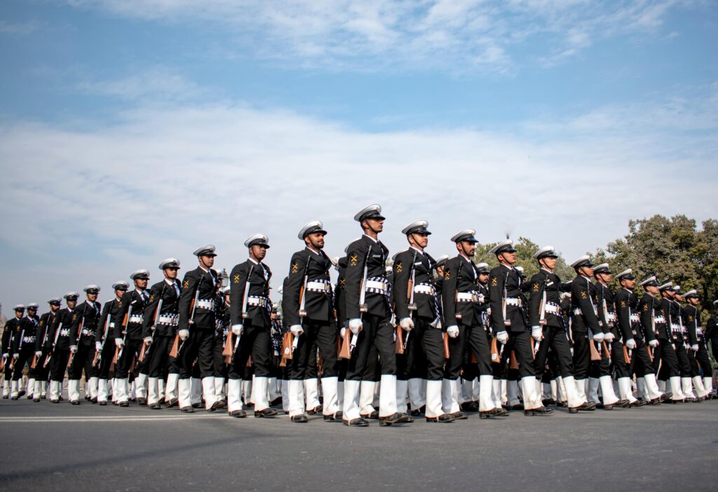 Indian naval officers in uniform marching in formation, showcasing discipline and unity during a parade in New Delhi.